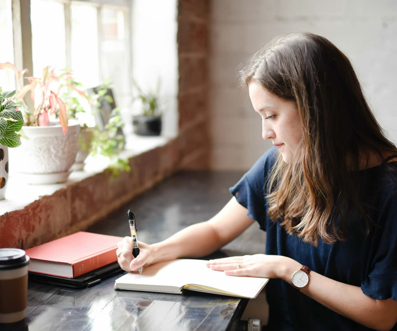 Woman writing in a cafe